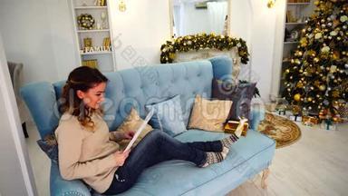 成功的女人在白天阅读商业文件，坐在装饰好的房间里，<strong>圣诞</strong>树。